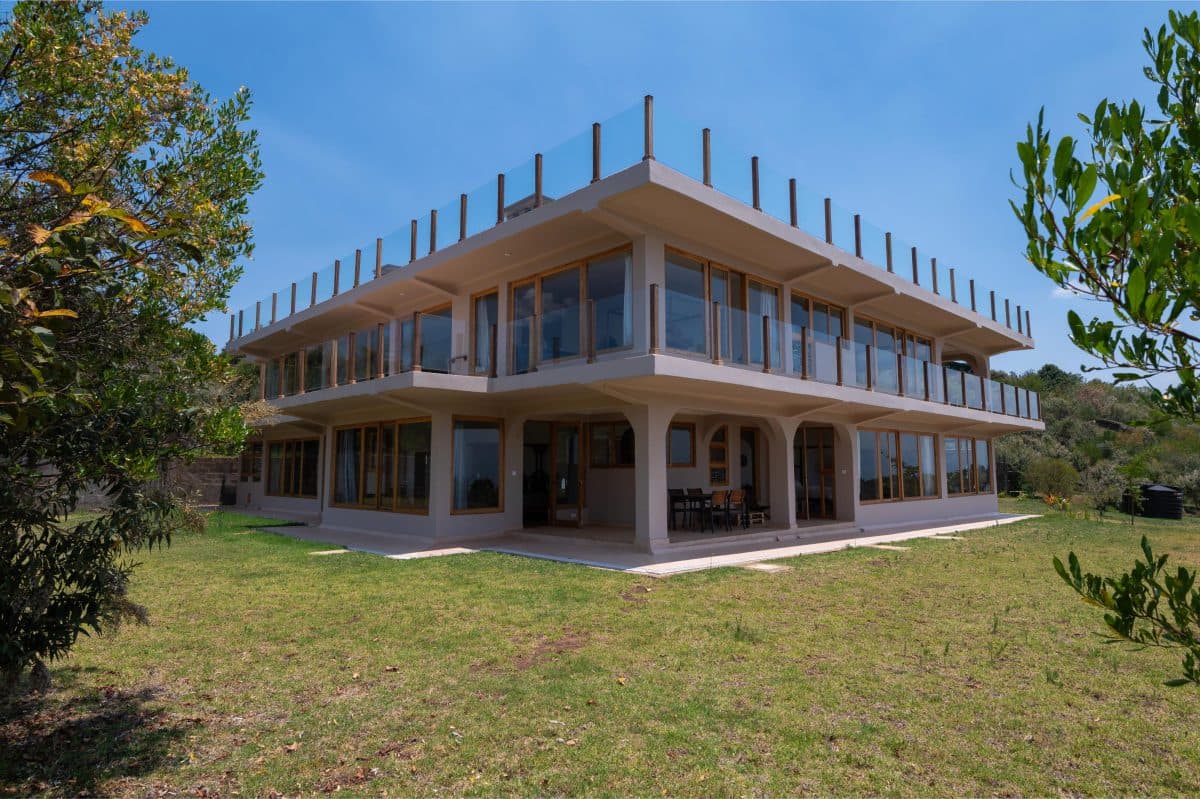 La Maison Bleue Naivasha — corner of the house with glass balconies and concrete floors