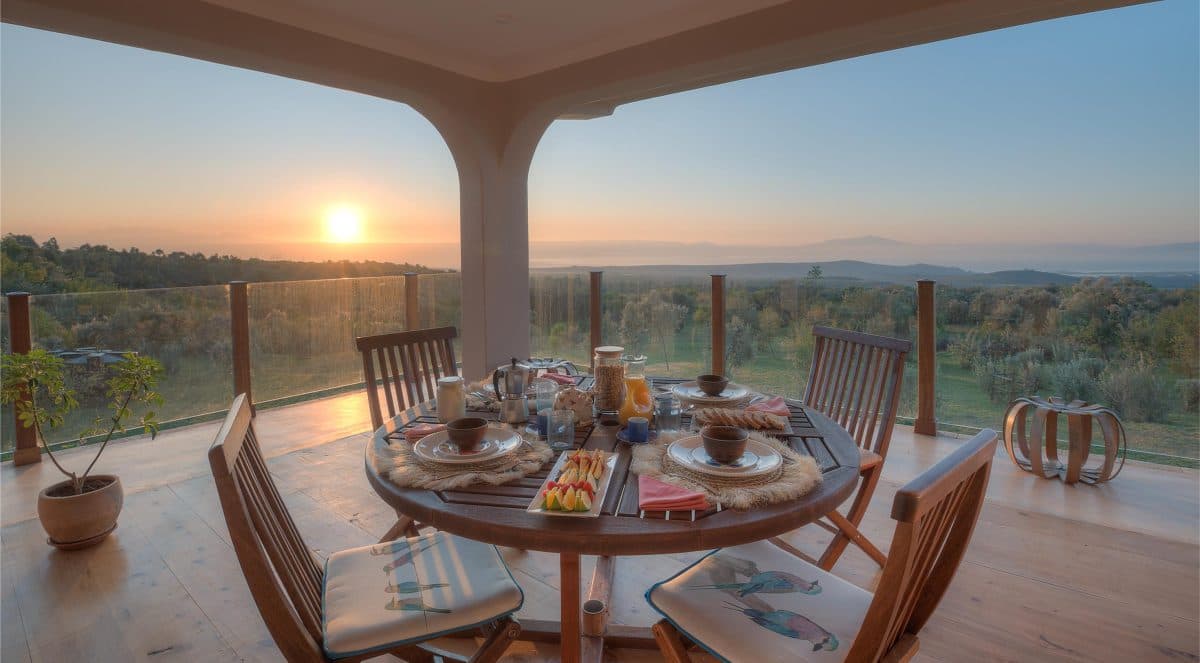 La Maison Bleue Naivasha — canopy bedroom with white linens and dusk valley views