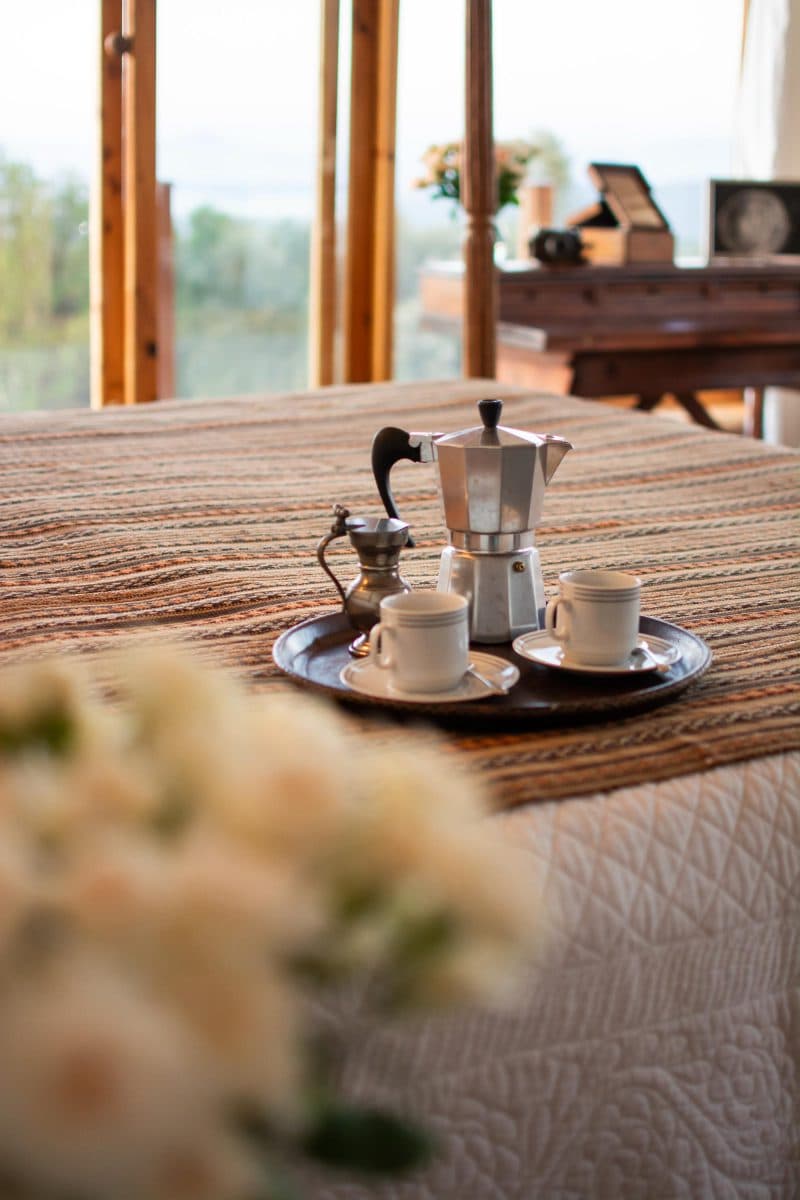 La Maison Bleue Naivasha — coffee service on the bed with white roses in the foreground
