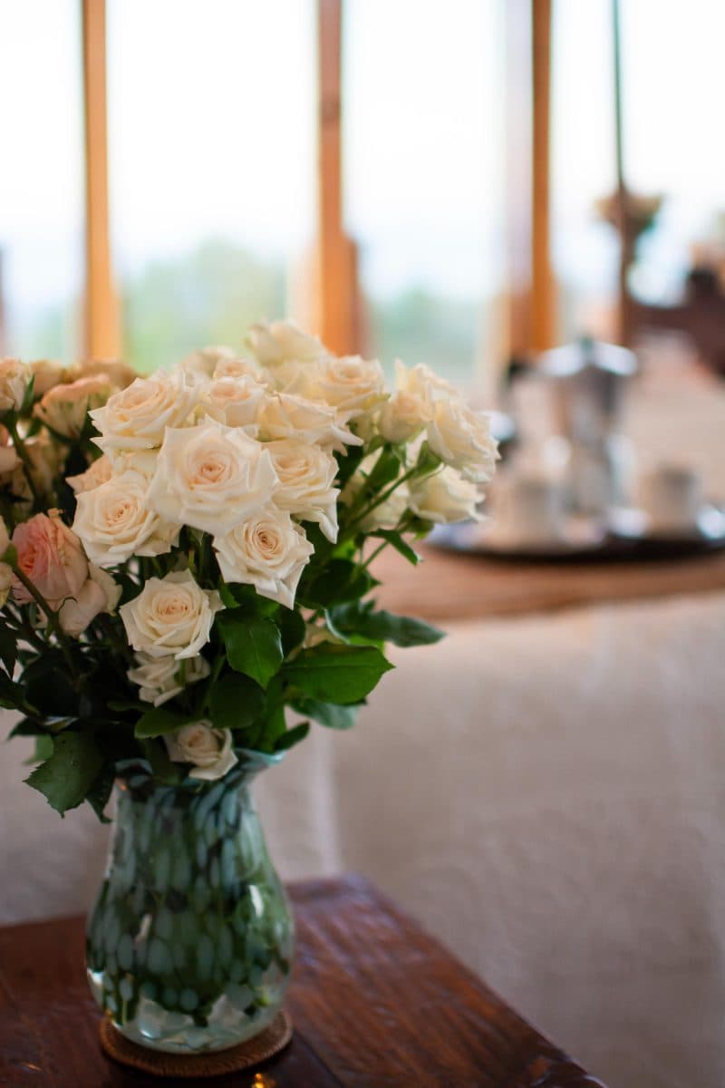 La Maison Bleue Naivasha — bouquet of white roses with the coffee tray softly beyond