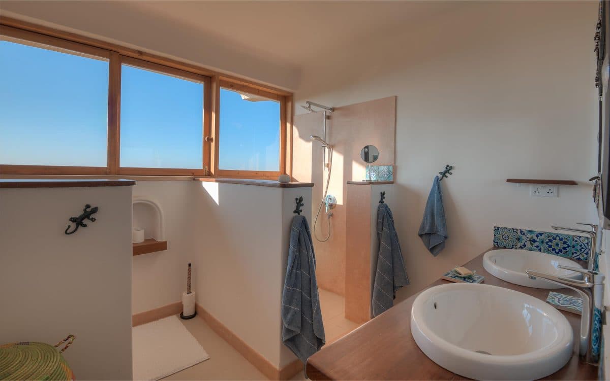 La Maison Bleue Naivasha — twin vessel sinks on a long wooden vanity with blue tiles