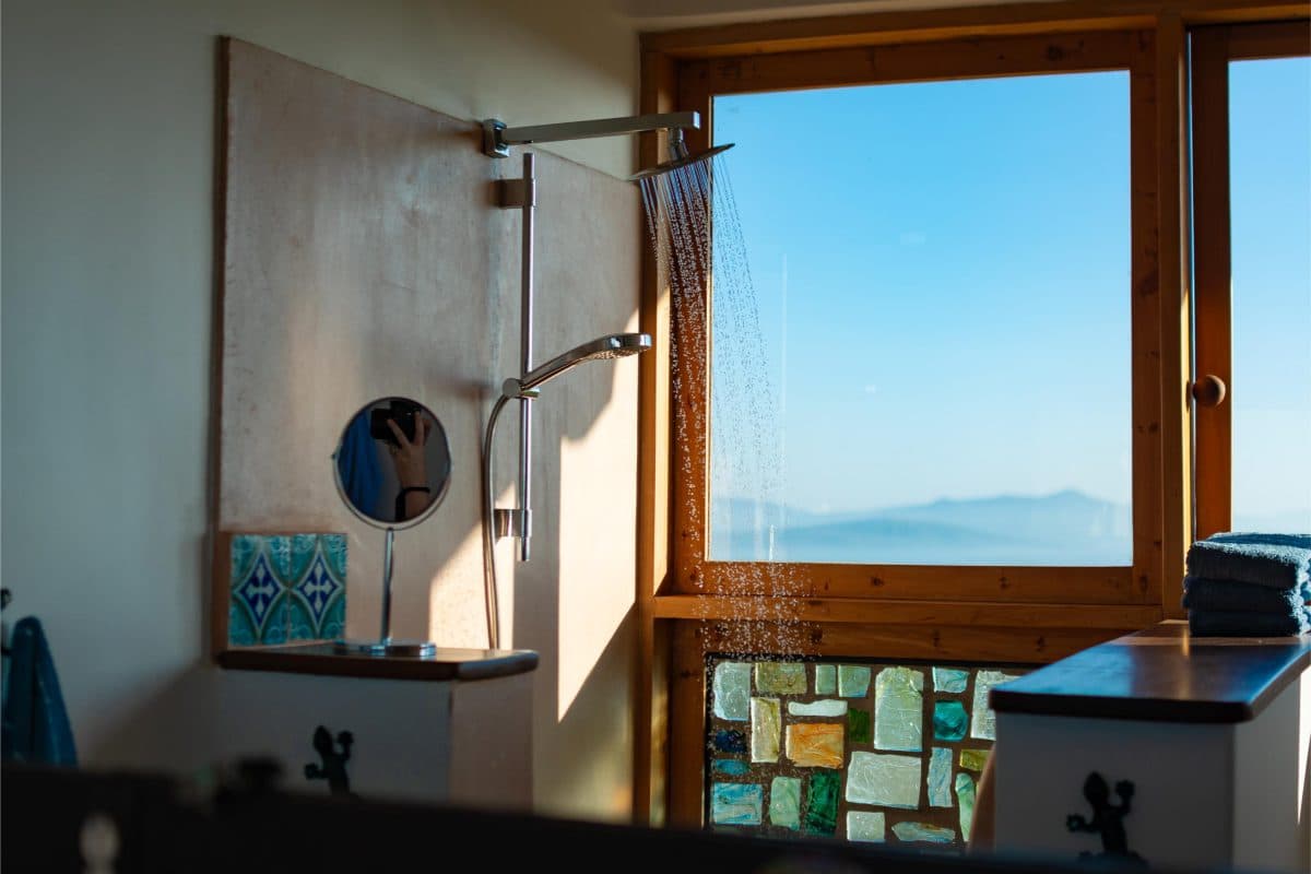 La Maison Bleue Naivasha — walk-in shower with a window framing distant mountains