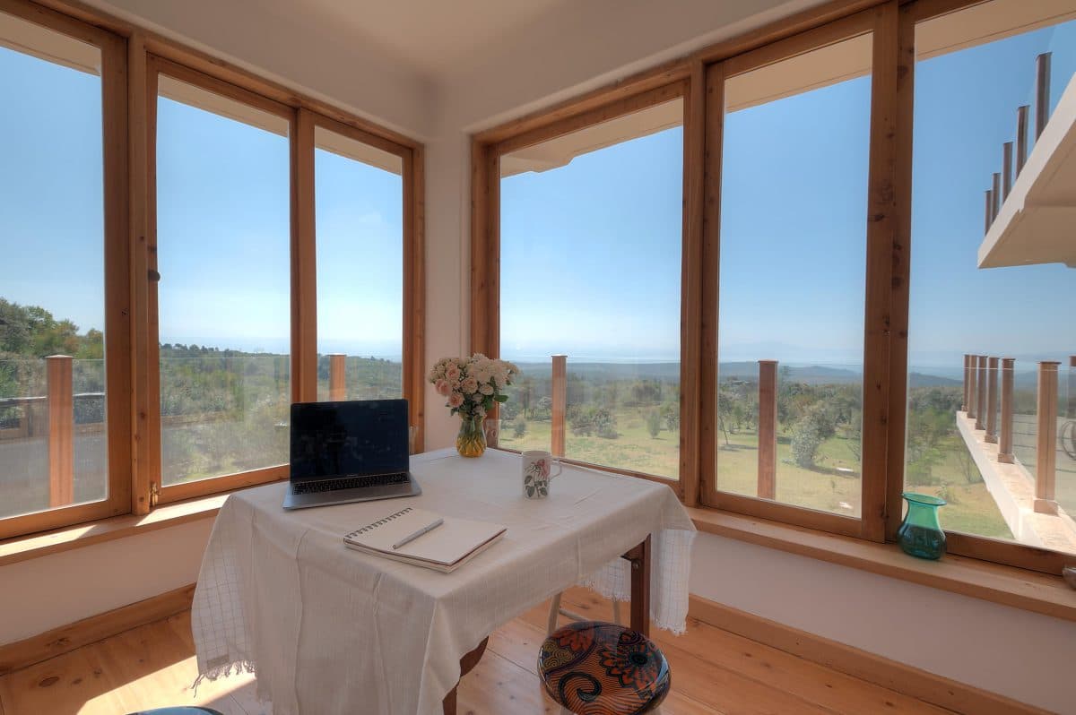 La Maison Bleue Naivasha — workspace table and laptop beside panoramic hillside views