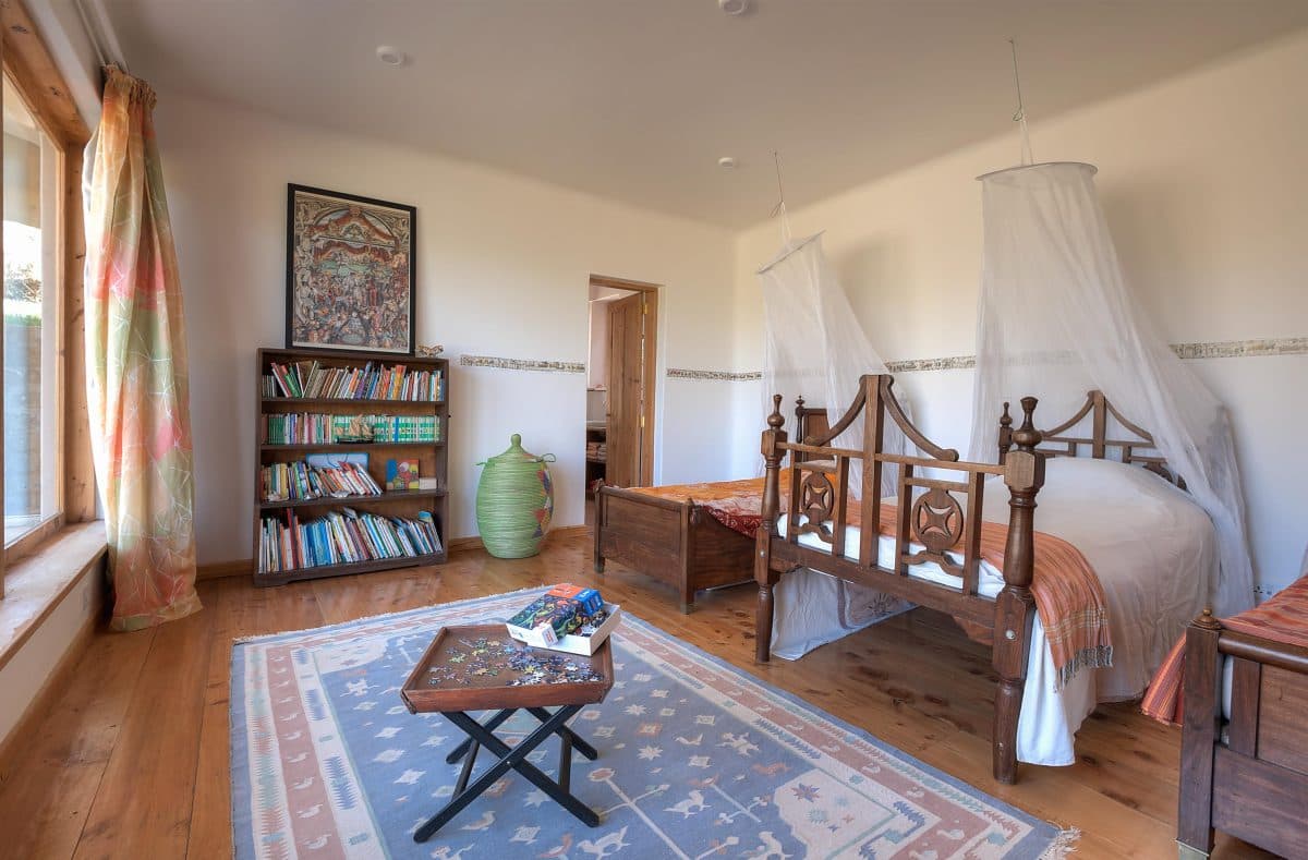 La Maison Bleue Naivasha — twin beds with mosquito nets, bookshelf and blue rug