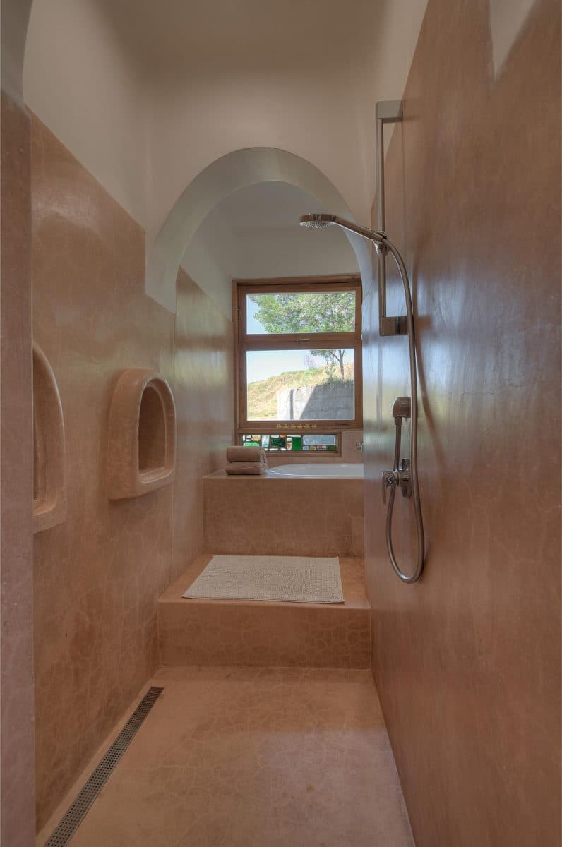 La Maison Bleue Naivasha — plaster-walled shower with chrome head and a small window