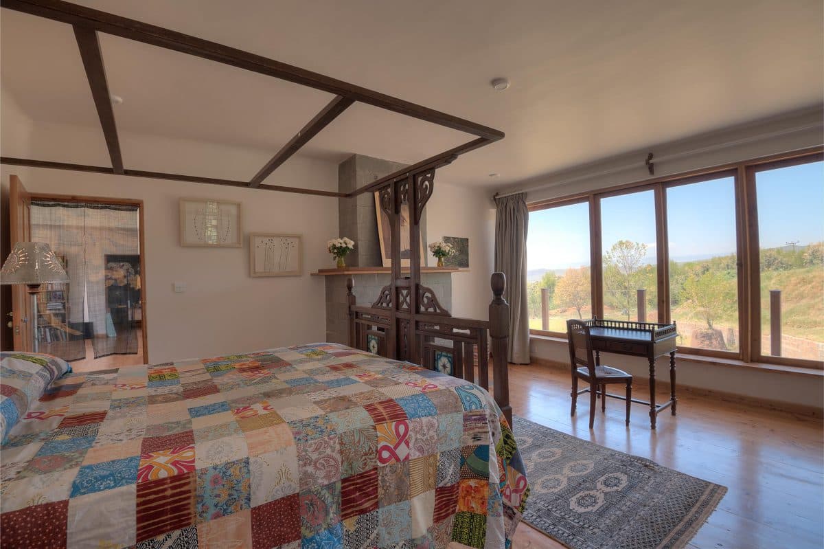 La Maison Bleue Naivasha — four-poster bed dressed with a colourful patchwork quilt