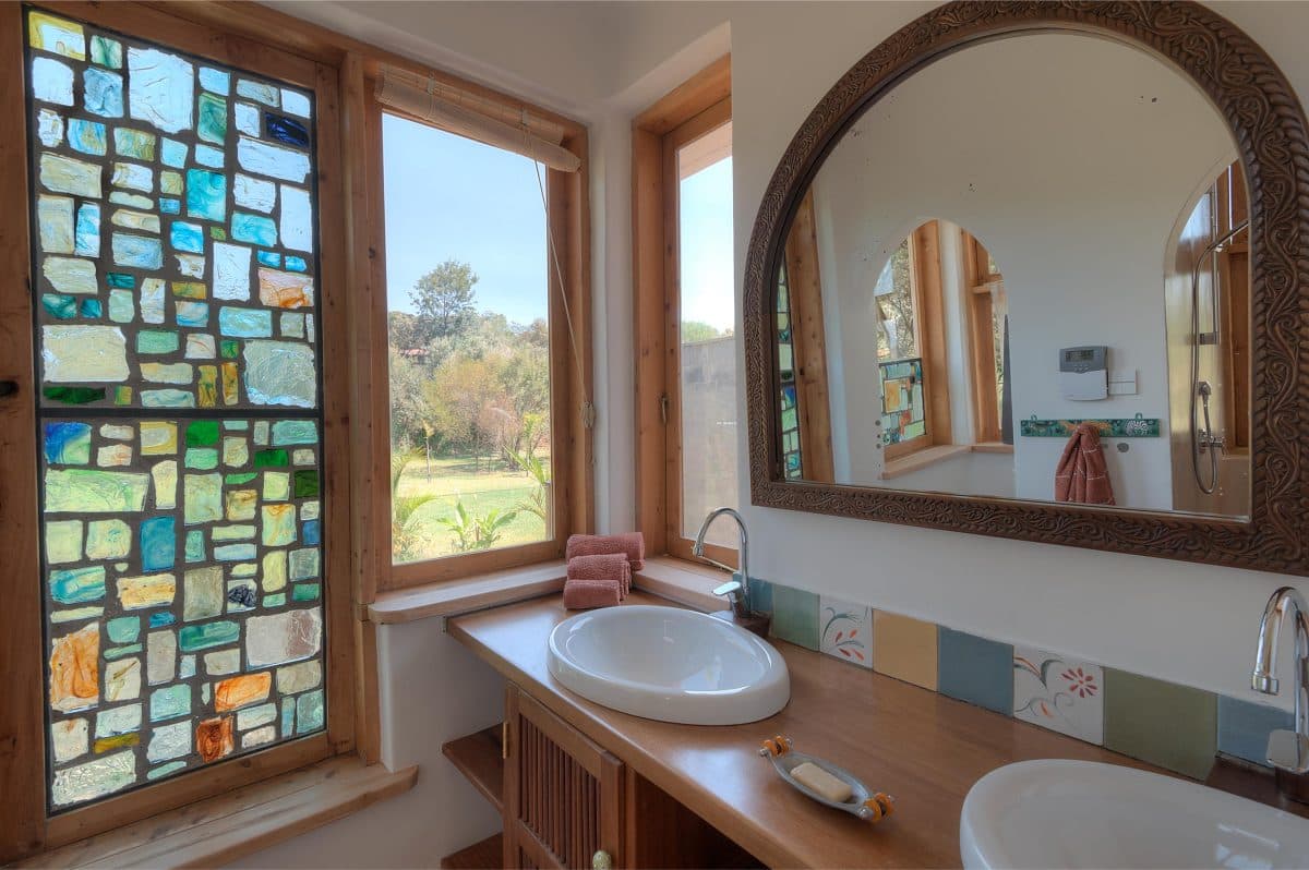 La Maison Bleue Naivasha — double vanity with arched mirror and mosaic glass window