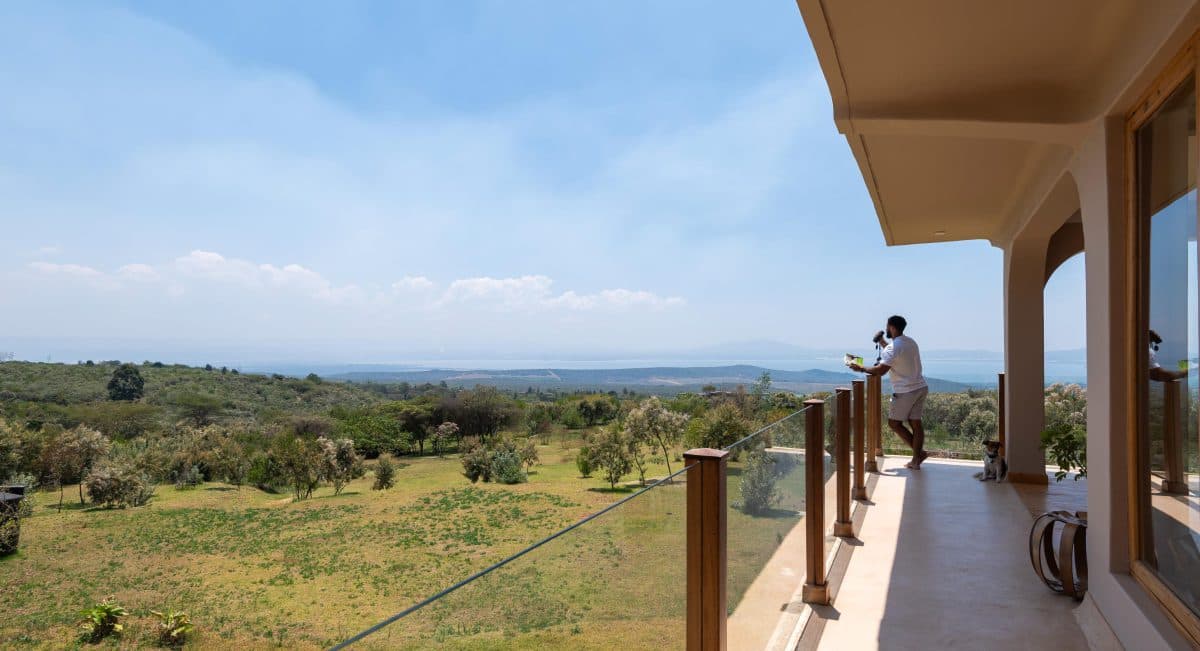 La Maison Bleue Naivasha — balcony with glass railing overlooking green countryside