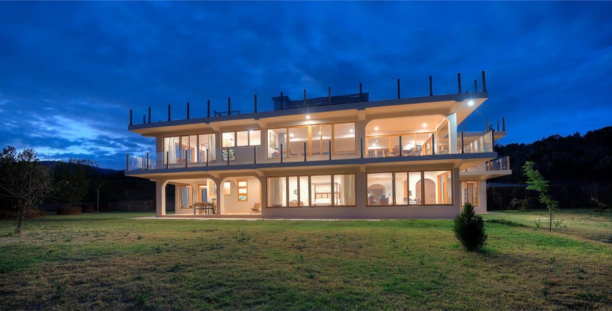 La Maison Bleue Naivasha — house glowing across the lawn at twilight